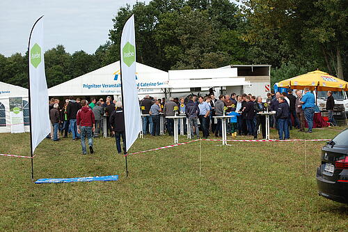 Gut besuchte Pavillons auf einem Feld. Am Eingang stehen Beachflags mit Logo von Avebe.