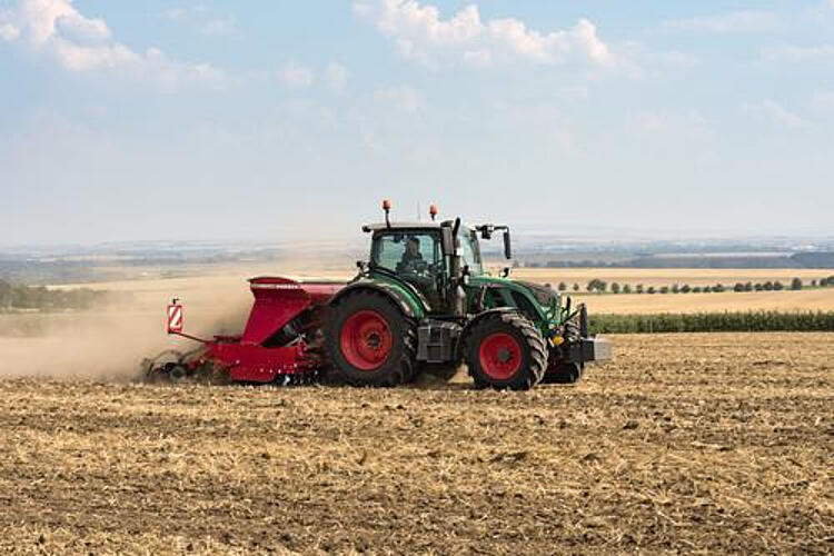 Grüner Traktor fährt über ein Feld.