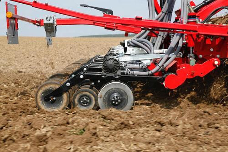 Rote Aussaatmaschine auf einem Feld.